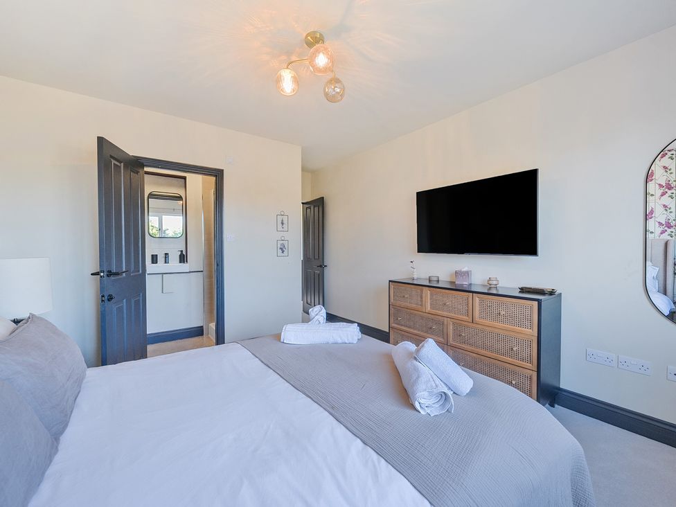 A bedroom with a bed and television at 8 Newmarket Road in Royston