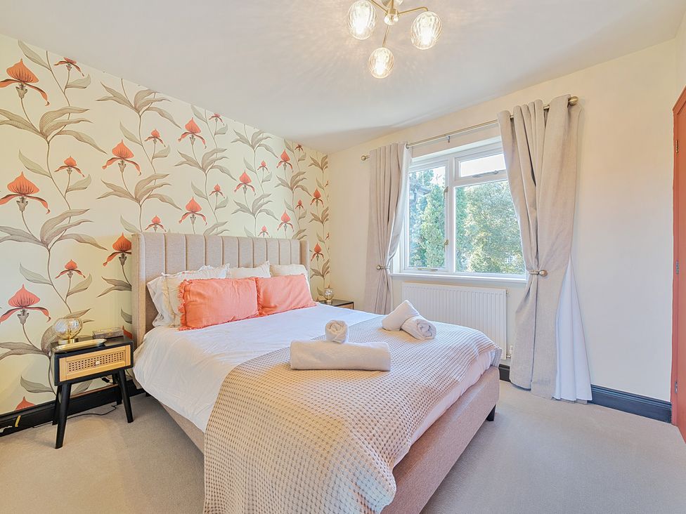 A bedroom with a bed and bedside table at 8 Newmarket Road in Royston