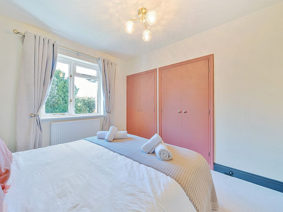 A bedroom with a bed and wardrobe at 8 Newmarket Road Royston