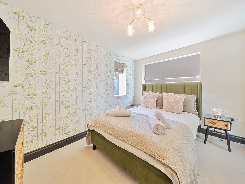 A bedroom with a bed and bedside table at 8 Newmarket Road Royston