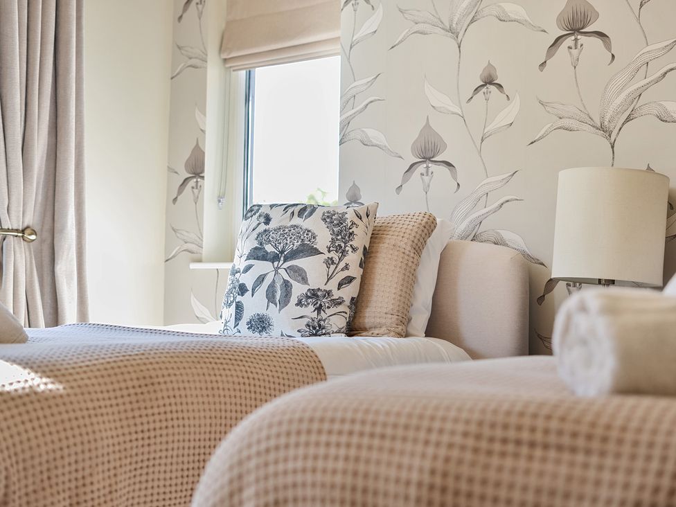 A bedroom with two beds and decorative pillows at 8 Newmarket Road Royston