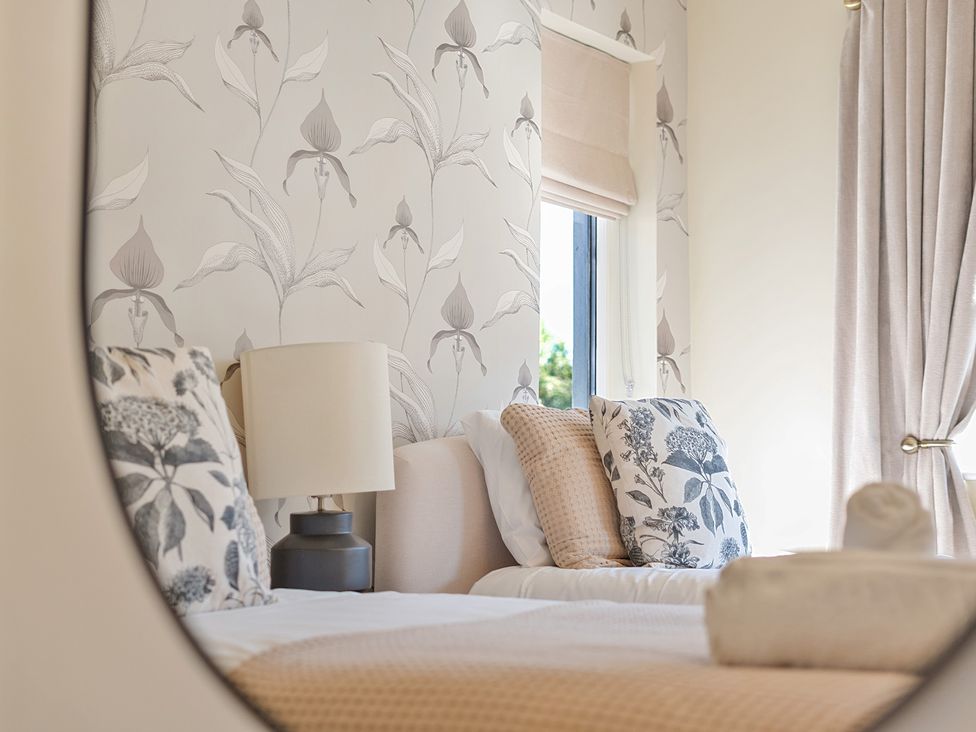 A bedroom with a bed, lamp, and decorative pillows at 8 Newmarket Road Royston