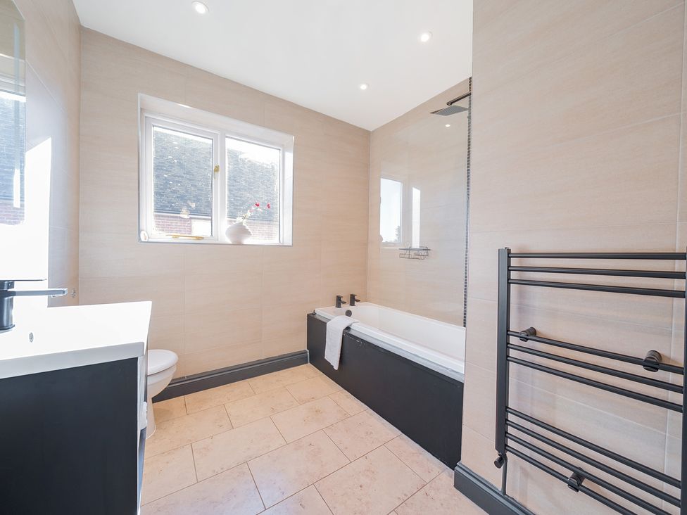 A bathroom with a sink, toilet, and bathtub at 8 Newmarket Road Royston