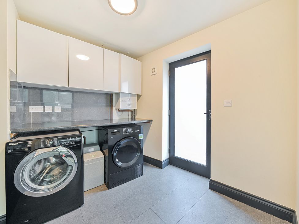 A utility room with a washing machine and dryer at 8 Newmarket Road Royston