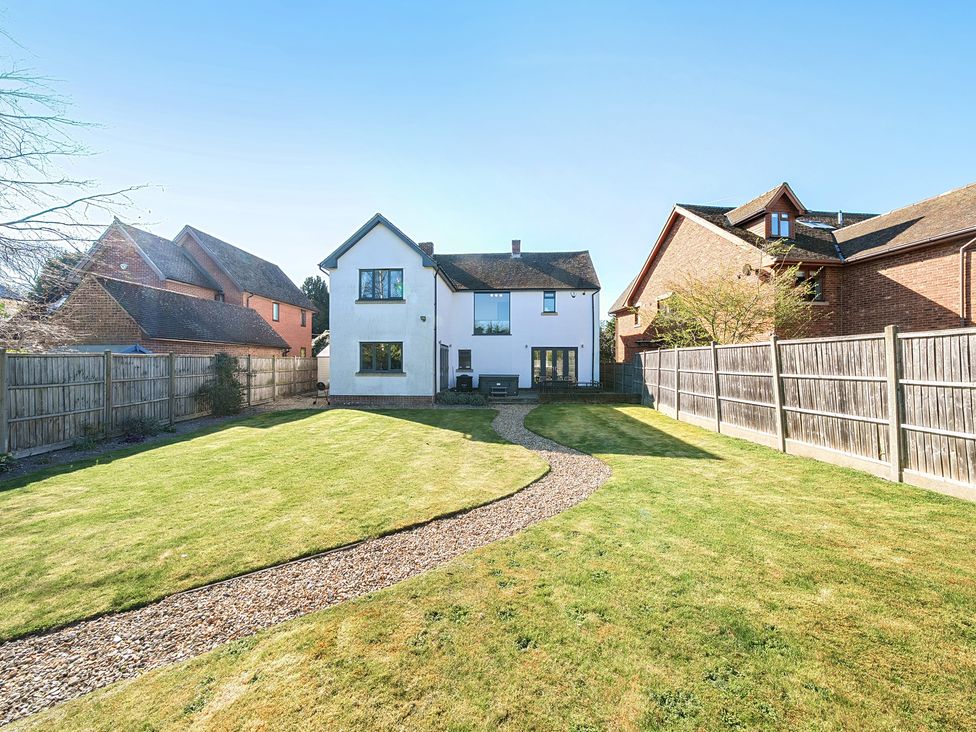 A garden with a pathway and house at 8 Newmarket Road Royston