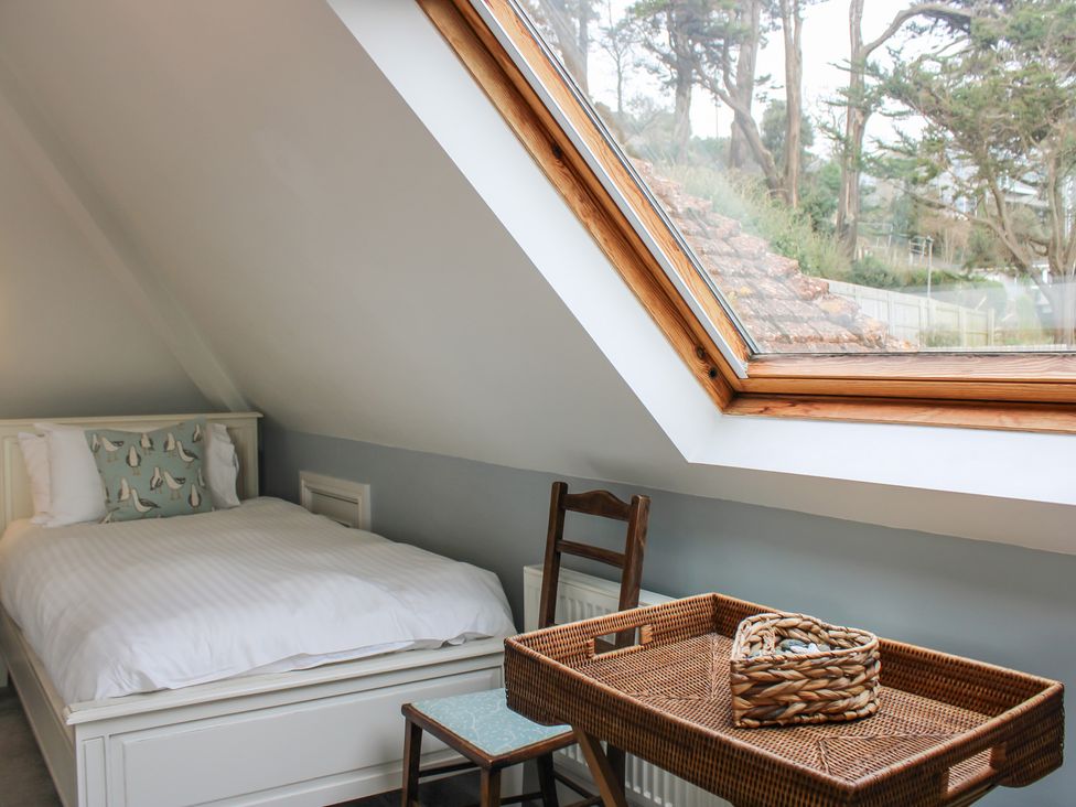 A bedroom with a bed and a table at 2 Channel View in Salcombe