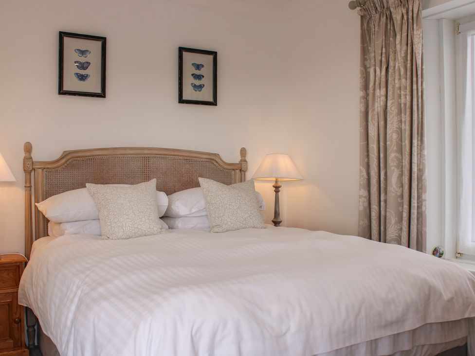 A bedroom with a double bed and bedside lamps at 2 Channel View in Salcombe