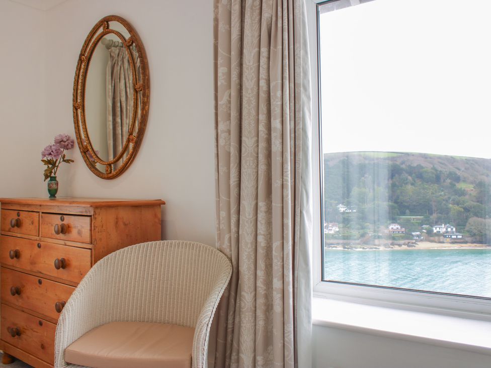 A bedroom with a dresser and a mirror at 2 Channel View Salcombe