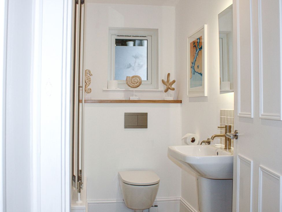 A bathroom with a toilet and sink at 2 Channel View Salcombe