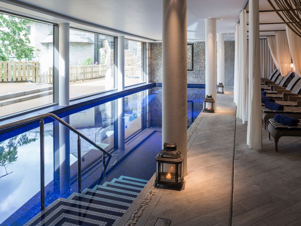 An indoor pool area with chairs and windows at 2 Channel View Salcombe