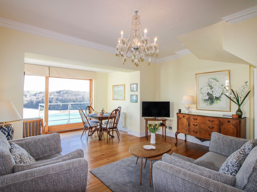 A living room with a sofa and a dining area at 2 Channel View in Salcombe
