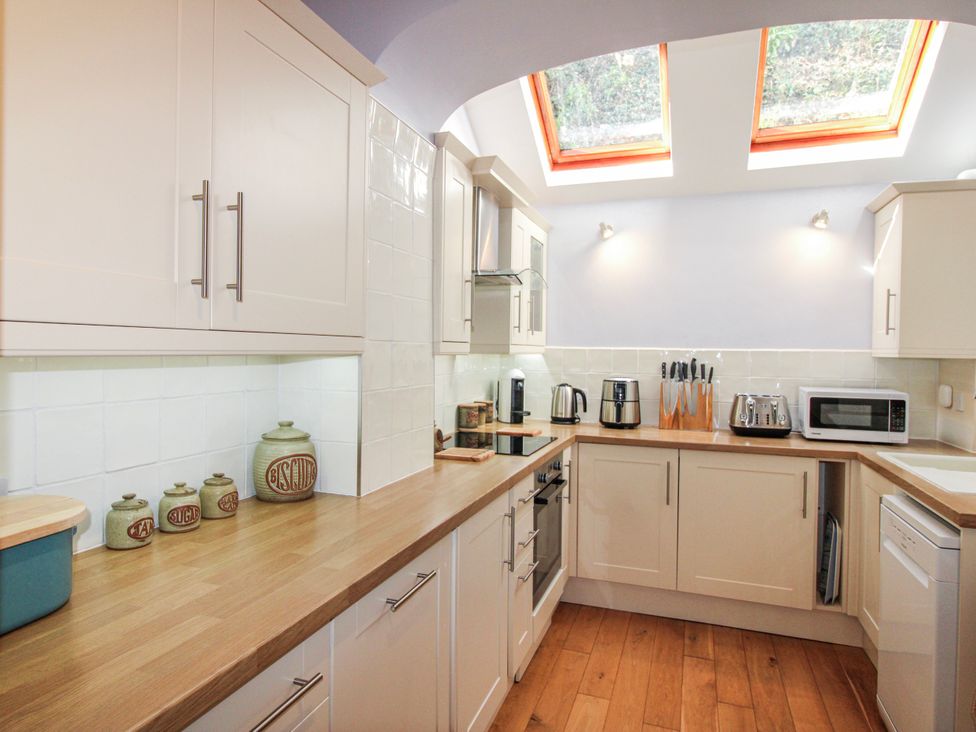 A kitchen with cabinets and appliances at 2 Channel View Salcombe