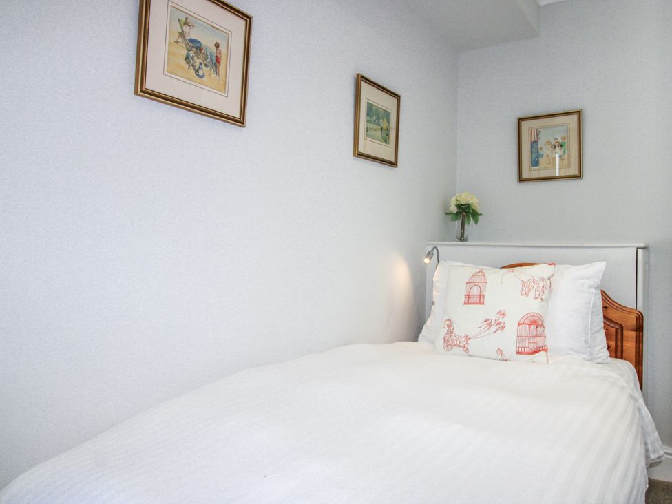 A bedroom with a bed and wall art at 2 Channel View in Salcombe