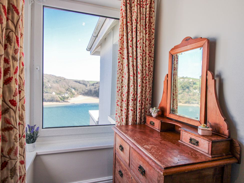 A bedroom with a window and a dressing table at 2 Channel View in Salcombe