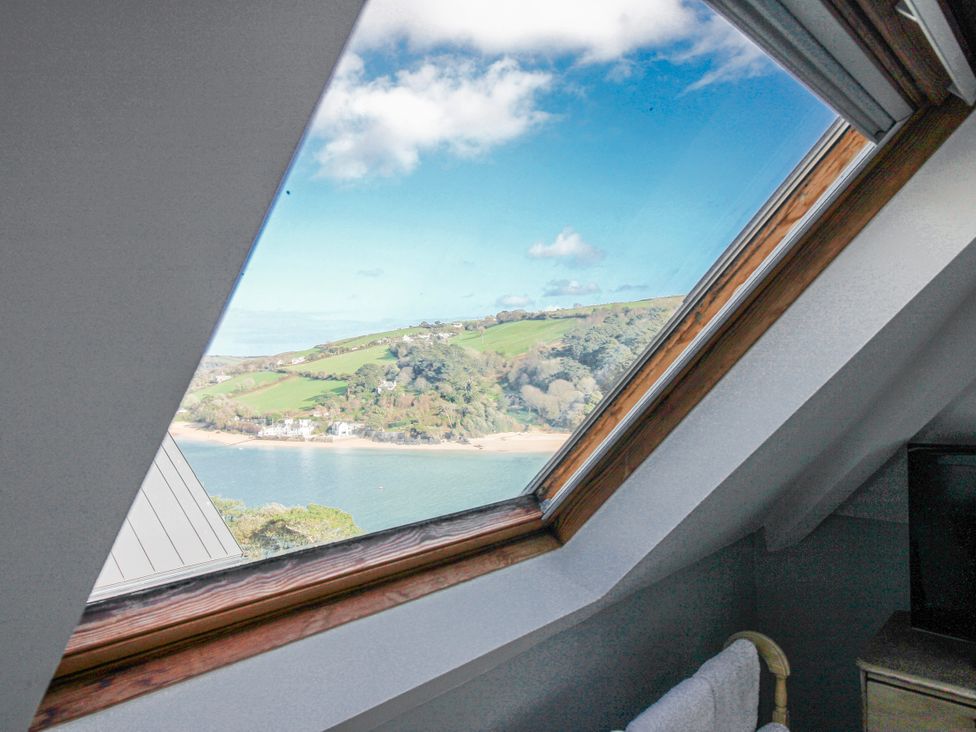A window showing a scenic view of hills and a river at 2 Channel View in Salcombe
