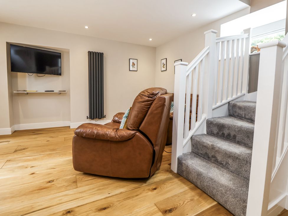 A living room with a recliner chair and television at Sunbird Cottage in Biddulph