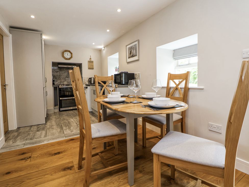 A dining area with a table and chairs at Sunbird Cottage in Biddulph