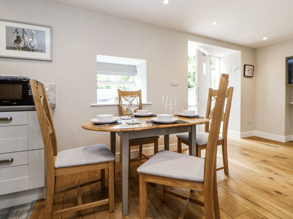 A dining room with a table set for meals at Sunbird Cottage in Biddulph