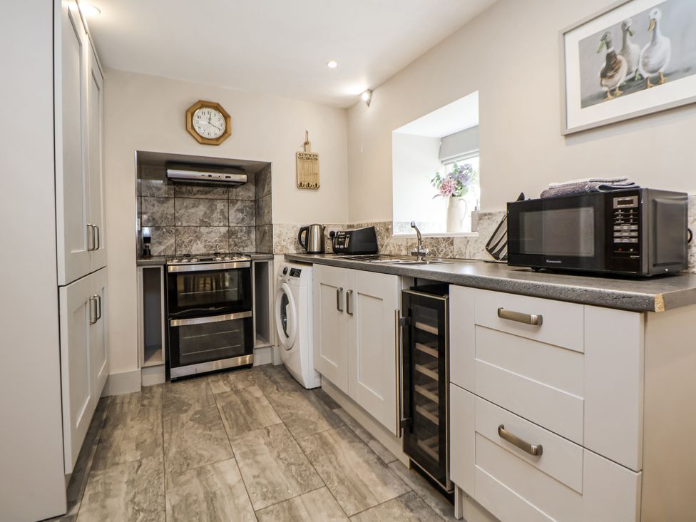 A kitchen with appliances including an oven and microwave at Sunbird Cottage in Biddulph