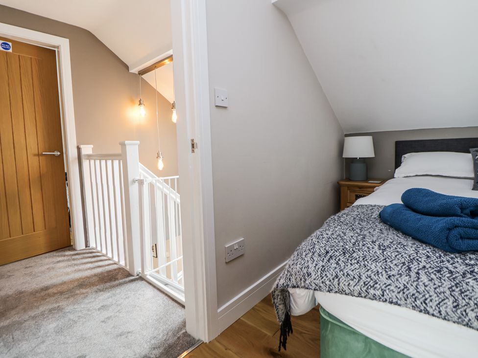 A bedroom with a bed and a side table at Sunbird Cottage in Biddulph