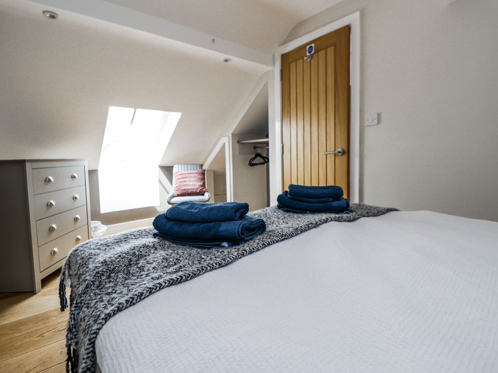 A bedroom with a bed and towels at Sunbird Cottage in Biddulph