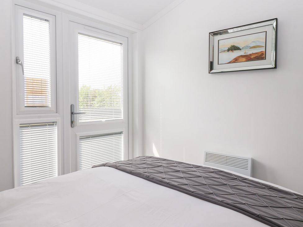 A bedroom with a bed and window at Bonny Bay in Wilsthorpe near Bridlington