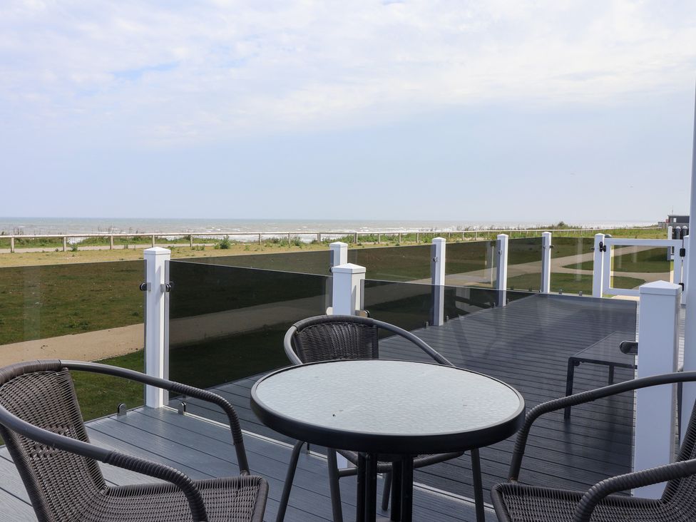 An outdoor terrace with a table and chairs at Bonny Bay in Wilsthorpe near Bridlington