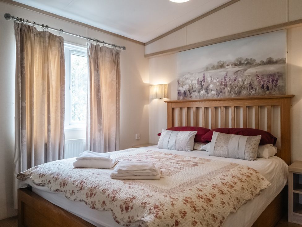 A bedroom with a bed and curtains at Willow in Swanage