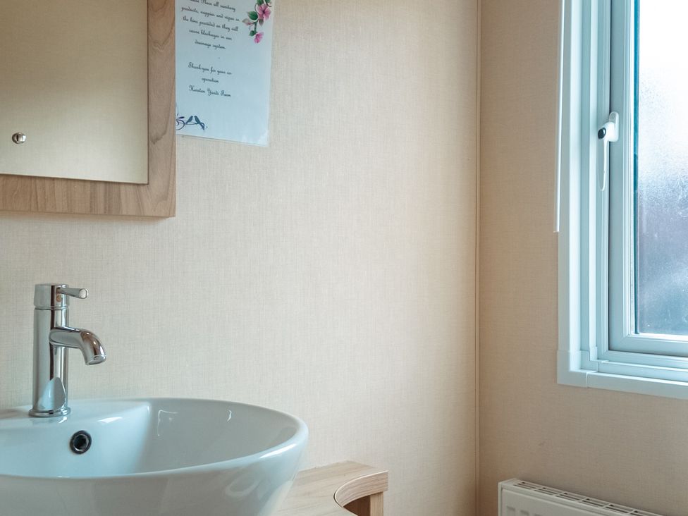 A bathroom with a sink and mirror at Willow in Swanage