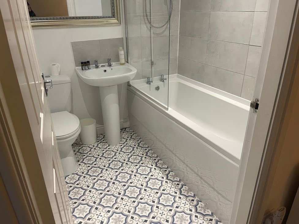 A bathroom with a toilet, sink, and bathtub at Bluebell Cottage in Brayton