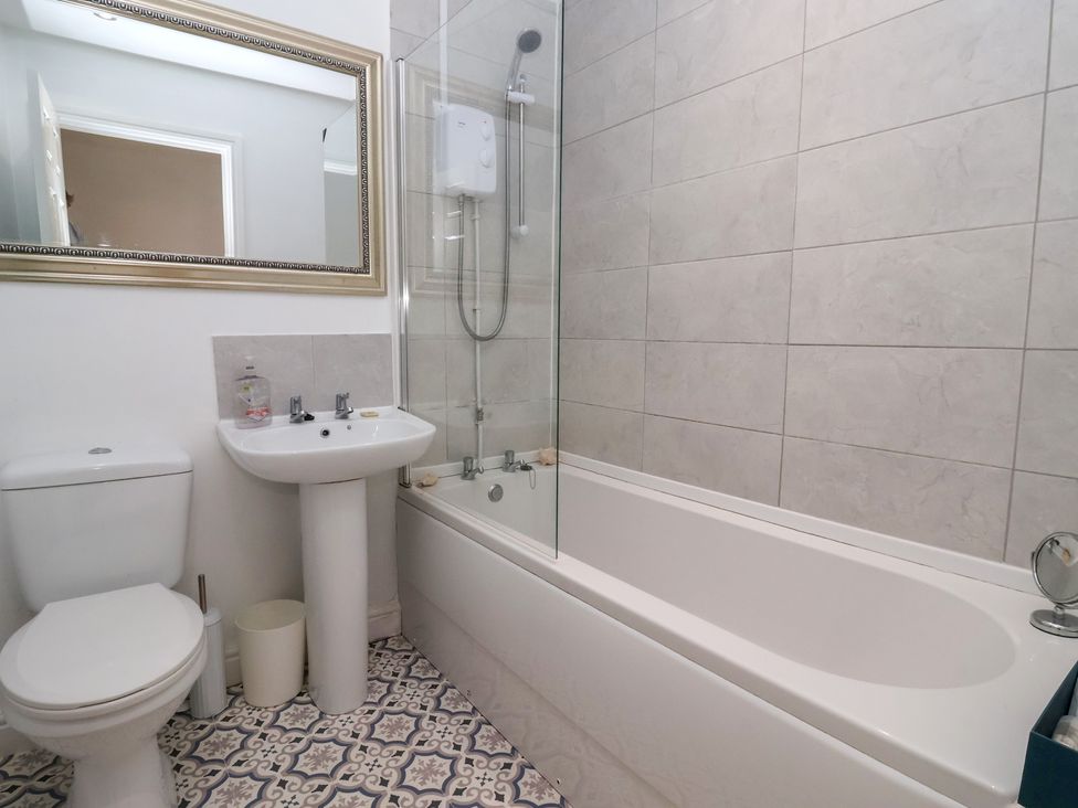 A bathroom with a toilet, sink, and bathtub at Bluebell Cottage in Brayton
