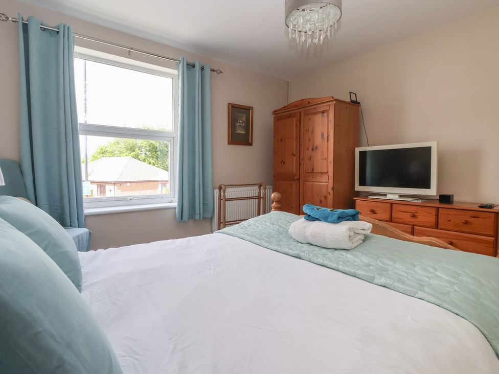 A bedroom with a bed and wardrobe at Bluebell Cottage in Brayton