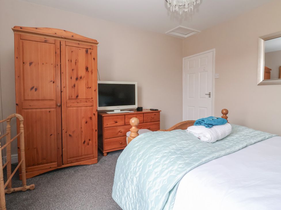 A bedroom with a wardrobe and television at Bluebell Cottage in Brayton