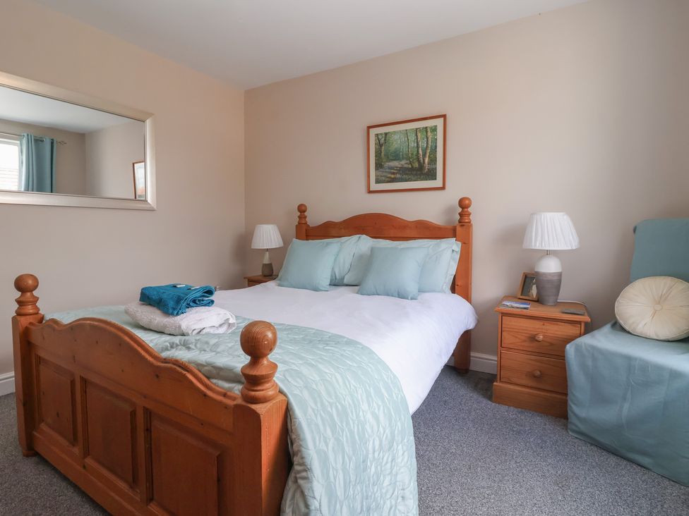 A bedroom with a bed and bedside table at Bluebell Cottage in Brayton