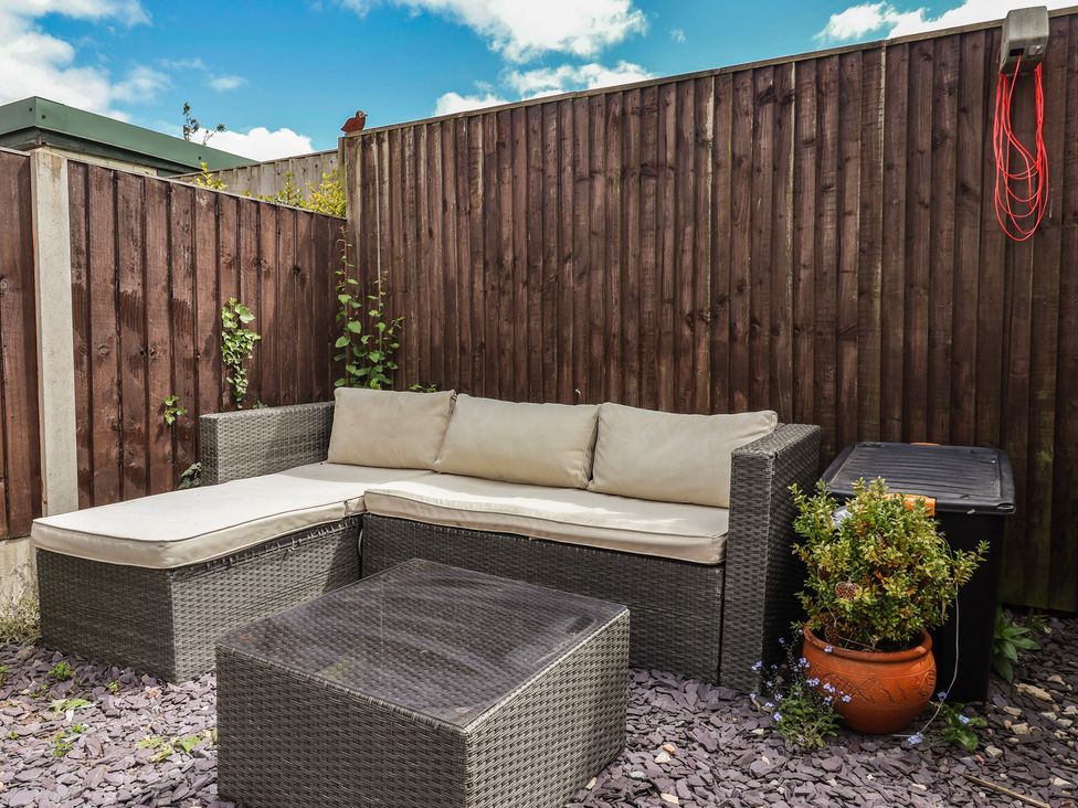 An outdoor sofa and coffee table in a garden at Bluebell Cottage in Brayton