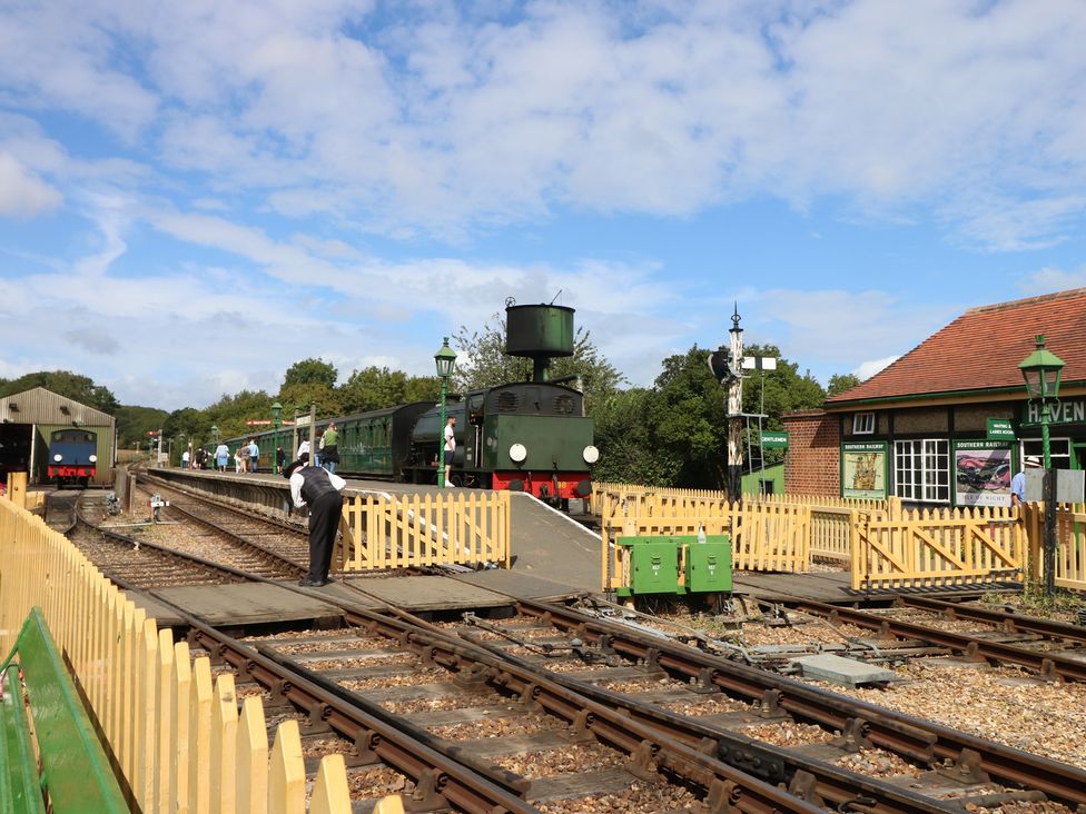 A train station with a green train and a station building at Haven in Yarmouth