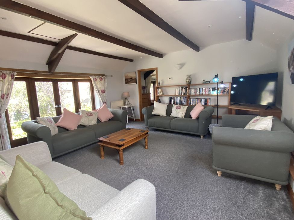 A living room with sofas and a television at Foxglove Barn in South Brent