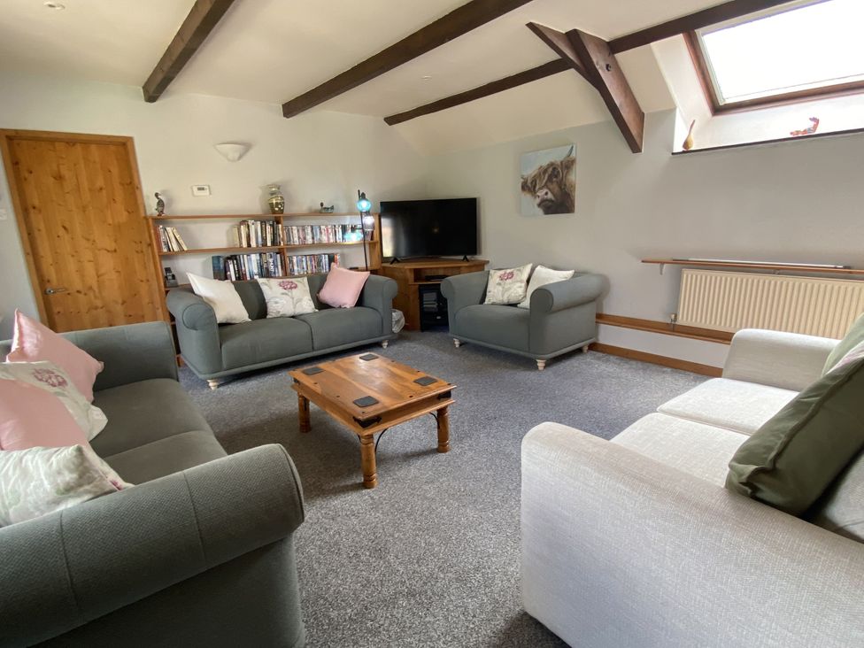 A living room with sofas and a television at Foxglove Barn in South Brent