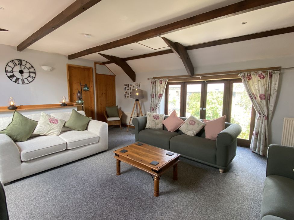 A living room with sofas and a coffee table at Foxglove Barn in South Brent