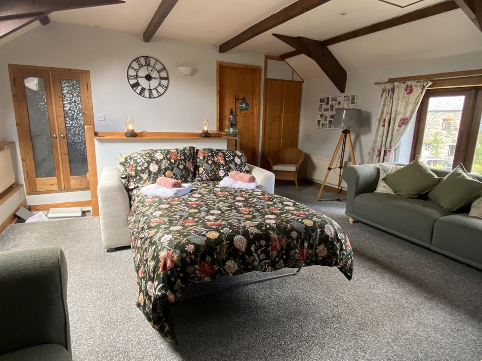 A living room with a sofa bed and chairs at Foxglove Barn South Brent