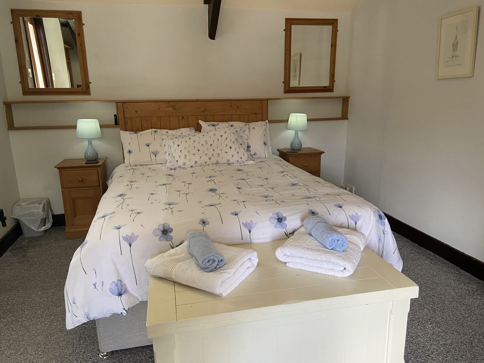 A bedroom with a double bed and bedside tables at Foxglove Barn South Brent
