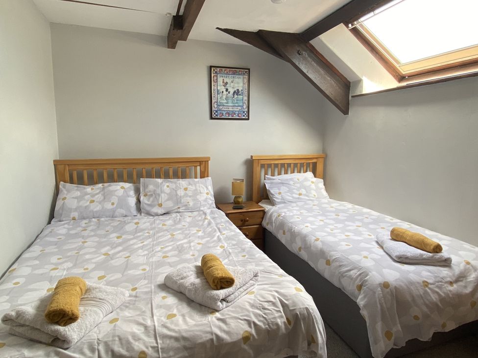 A bedroom with a double bed and a single bed at Foxglove Barn South Brent