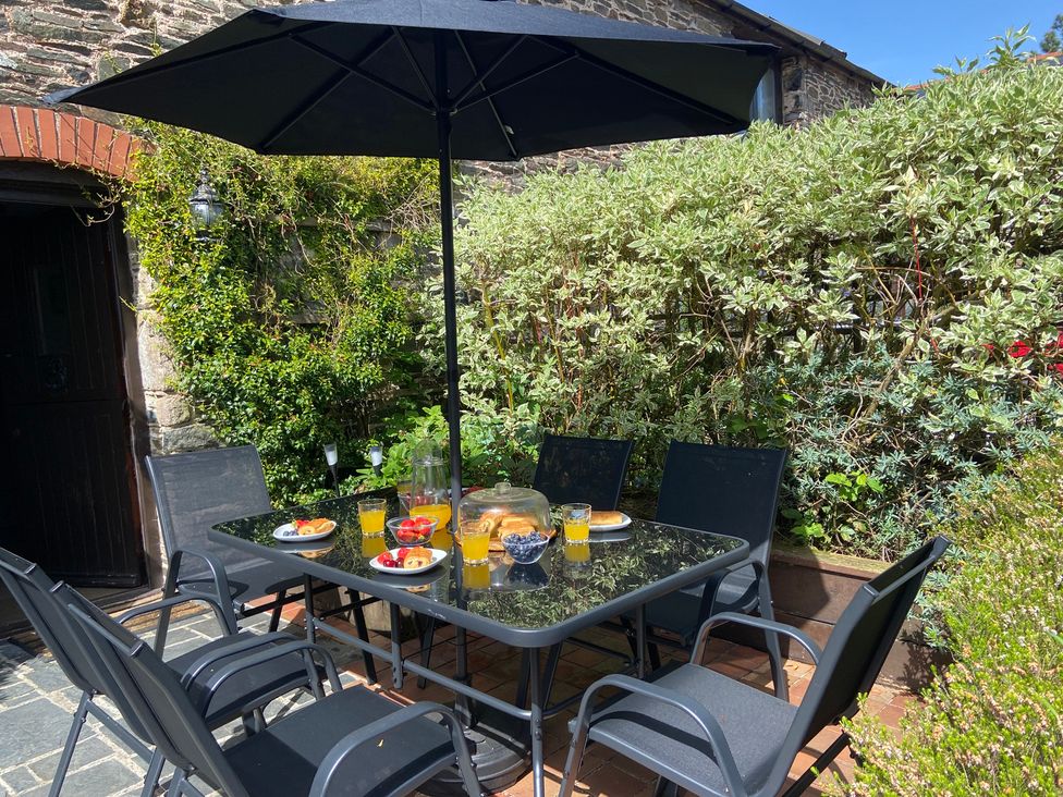 A table with chairs and fruit at an outdoor dining area at Foxglove Barn South Brent