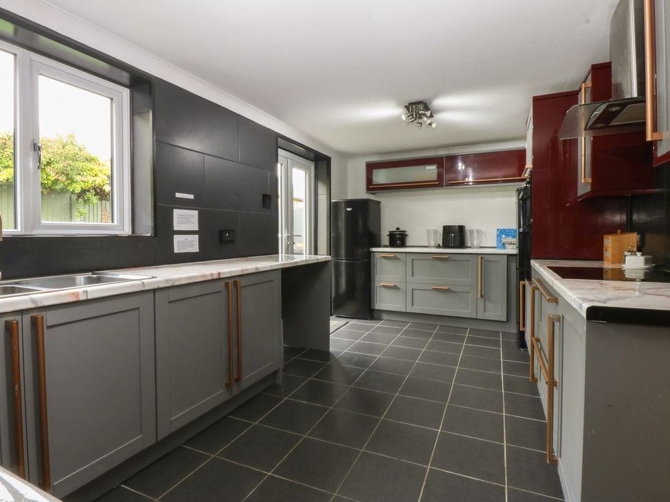 A kitchen with a sink, fridge, and countertop at 2 Trem Y Don in Colwyn Bay
