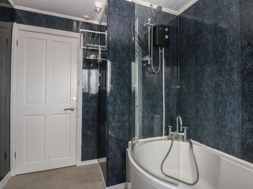 A bathroom featuring a bathtub and shower at 2 Trem Y Don in Colwyn Bay