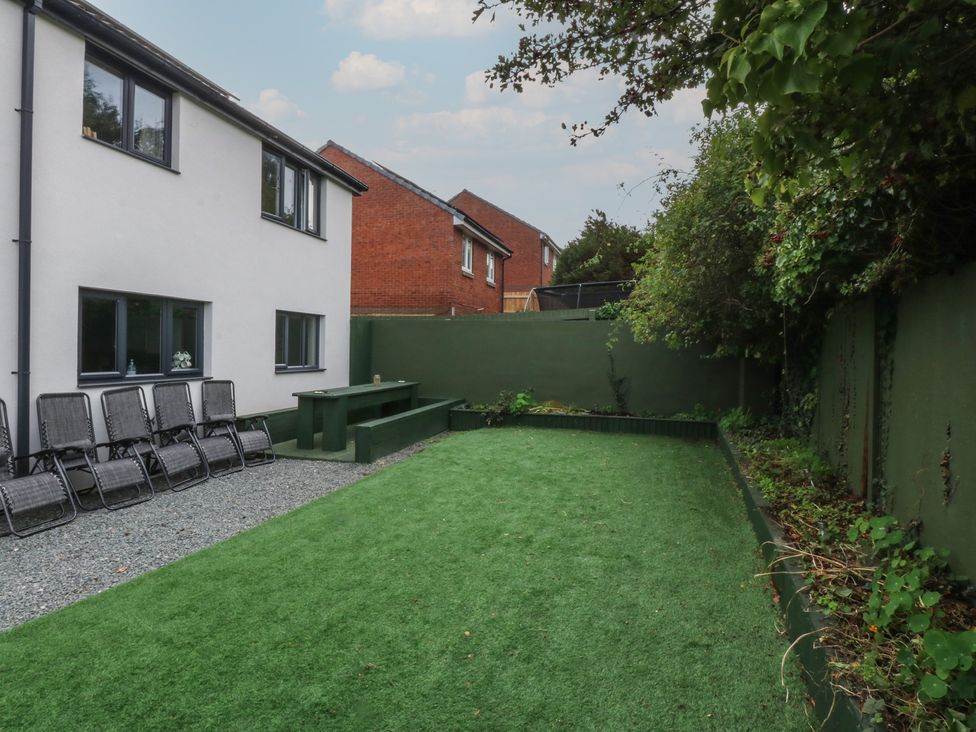 A garden with a seating area and green grass at 2 Trem Y Don in Colwyn Bay
