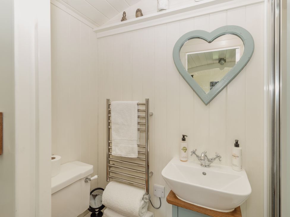 A bathroom with a toilet, sink, and towel rail at Hurdlemakers Hut in Piddletrenthide