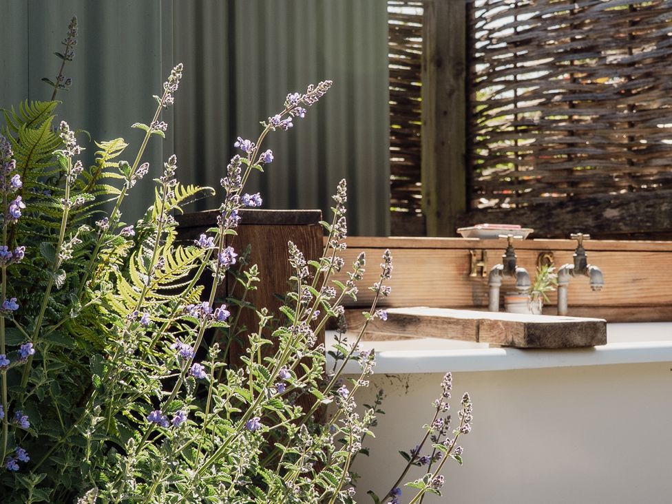 An outdoor area with flowers and a sink at Hurdlemakers Hut in Piddletrenthide