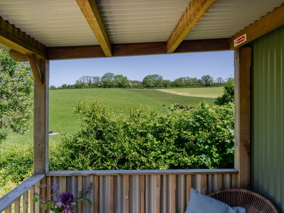 An outdoor area with a view of a green field at Hurdlemakers Hut in Piddletrenthide