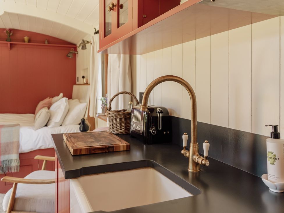 A kitchen with sink and cutting board at Spindleberry Hut in Piddletrenthide